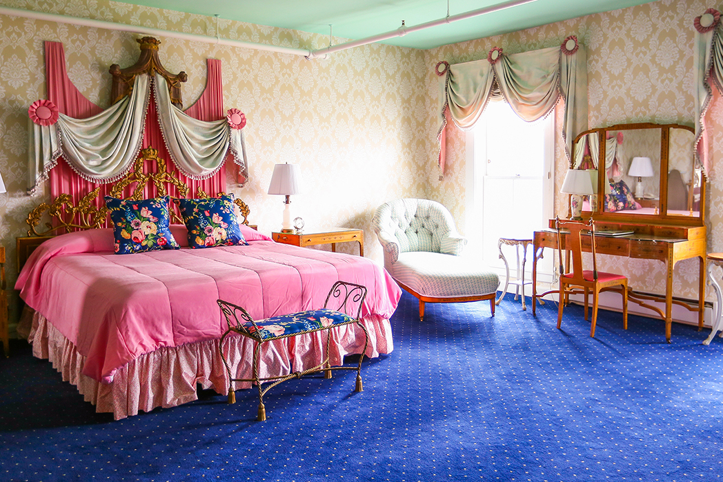 Image of Suite at the Grand Hotel with bubblegum pink duvet covers and canopy overhead. Grand Hotel, a member of Historic Hotels since 2001, dates to 1886. It is located in Mackinac Island, Michigan.